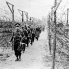 Un soldado brit&aacute;nico conduce a los prisioneros alemanes por un campamento, en alg&uacute;n punto del Reino Unido, pocos d&iacute;as despu&eacute;s del desembarco.