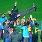 FC Barcelona players and staff members toss their head coach Pep Guardiola as they celebrate their victory against Santos FC during the awarding ceremony after the final football match in the Club World Cup in Yokohama on December 18, 2011. Bar...