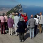 Un grupo de turistas escucha a su gu&iacute;a, divisando el Pe&ntilde;&oacute;n.