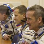 The International Space Station (ISS) crew members, from left: Russian cosmonaut Roman Romanenko, U.S. astronaut Thomas Marshburn and Canadian astronaut Chris Hadfield speak with relatives after putting on their space suits at the Baikonur cosmo...