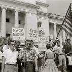 Un grupo de racistas porta banderas y carteles en contra de la mezcla racial en 1959, bajo lemas como &quot;la mezcla racial es comunismo&quot;.