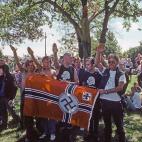 Un grupo de neonazis hacen el saludo de su grupo enarbolando una bandera nazi en Chicago en 1988.

