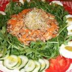Lleva atún, zanahoria, tomates, quesitos, rúcula, pepinillos, pepino y zumo de lima. Puedes ver la receta completa en Cookpad.