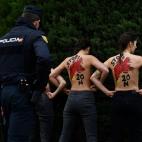 Spanish policemen surround members of the feminist movement Femen as they protest against a far right demonstration marking the anniversary of the death of Spanish late dictator Francisco Franco in Madrid on November 24, 2019. (Photo by OSCAR DE...