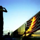 Un joven quema una bandera en la frontera entre EEUU y México en la zona entre San Diego y Tijuana.