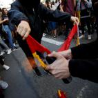 Manifestantes queman una bandera de España
