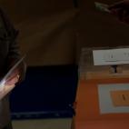 Un señor prepara su voto en su sobre