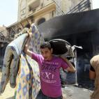 Un opositor saca diversos objetos de la sede quemada de los Hermanos Musulmanes en El Cairo.