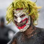 A reveller wears a Joker mask during the "Bloco da Lama", a mud carnival party, in Paraty, Rio de Janeiro state, Brazil, on February 22, 2020. - "Bloco da Lama" started in 1986 with teenagers playing with mud and became a traditional event at th...