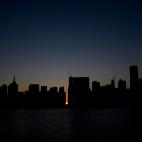 TOPSHOT - The sun sets behind 42nd Street in Manhattan during a power outage in New York City on July 13, 2019. - Subway stations plunged into darkness and the billboards of Times Square suddenly flicked off as New York's Manhattan was hit by a ...