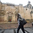 Una mujer se cubre la cabeza con un pañuelo para resguardarse de la intensa lluvia caía en Córdoba