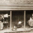 1887: Una niña mira por una cámara hecha con un taburete y una maceta para jugar a fotografiar a su amiga (Foto de Rev F. C. Lambert/Hulton Archive/Getty Images)