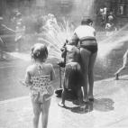 En torno a 1970: niños juegan en una calle de Nueva York con un surtidor de agua. (Foto de Peter Keegan/Keystone/Getty Images)