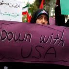 Una iran&iacute; sostiene un cartel en las protestas de este mi&eacute;rcoles en Teher&aacute;n en el que puede leerse en ingl&eacute;s: &quot;Abajo con Estados Unidos&quot;.