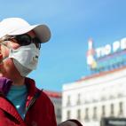 Una mujer pasea por la Puerta del Sol de Madrid con la mascarilla