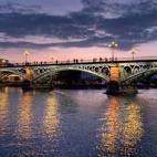 Ya lo decía la canción: "Sevilla tiene un color especial". Lo que no decía es que de noche, en el Puente de Isabel II, mucho más conocido como el Puente de Triana, ese color es todavía más especial. La arquitectura se mezcla con la natural...