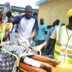 In a Sunday, Dec. 25, 2011 file photo, medical officials try to treat a victim of a bomb blast at a Catholic church near Nigeria's capital at Suleja General Hospital in Suleja, Nigeria. An explosion ripped through a Catholic church during Christ...