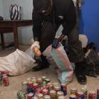 An anti bomb police officer collect soft drink can bombs recovered from islamic militants in Kano, Nigeria, on Tuesday, Jan. 24, 2012. Police said Tuesday that members of the radical Islamist group Boko Haram dressed in uniforms resembling those...