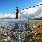 El artista Kane Petersen camina sobre una cuerda a 300 metros de altura sobre el suelto en Melbourne, Australia.