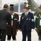 Barack Obama saluda a hombres vestidos de bávaros al salir de Munich, Alemania, al final de la cumbre del G7.