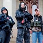 Armed protesters provide security as demonstrators take part in an "American Patriot Rally," organized on April 30, 2020, by Michigan United for Liberty on the steps of the Michigan State Capitol in Lansing, demanding the reopening of businesses...