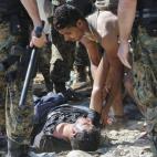 Un refugiado ayuda a un compañero exhausto tras cruzar la frontera entre Macedonia y Grecia cerca de Gevgelija, Macedonia, el 2 de septiembre del 2105. 