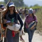 Varios refugiados cruzan la frontera entre Macedonia y Grecia, cerca del pueblo de Gevgelija, Macedonia. Las organizaciones que prestan ayuda a inmigrantes y refugiados señalan que unas 30.000 personas atraviesan la frontera a diario y que una ...