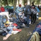 Inmigrantes se reparten la ropa que han donado para ellos en un parque cerca de la oficina de inmigración en Bruselas, el 2 de septiembre.
