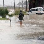 Un hombre intenta cruzar la entrada Norte de Orihuela por la N-340, cortada debido a las inundaciones.