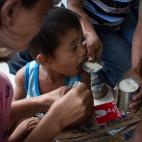 Familias evacuadas y niños del tifón Yolanda reciben las primeras y más básicas ayudas del Gobierno y las organizaciones internacionales en Taclobán el 13 de noviembre de 2013.
