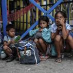 Un grupo de niños filipinos, víctimas evacuadas del tifón Yolanda, esperan en las proximidades del aeropuerto de Taclobán el 13 de noviembre de 2013.