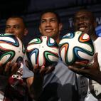 El exjugador de fútbol Cafú (izq.) y los jugadores de fútbol Hernane Vidal de Souza y Clarence Seedorf (dch.) con el balón oficial del Mundial Brasil 2014.