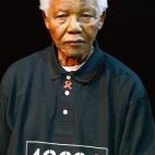 Mandela posa con una camiseta con su número de preso en Robben Island. El 46664 fue el símbolo que se utilizó en una campaña contra el sida promovida por él mismo.