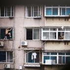 Un hombre trepa por la fachada de un edificio con un cuchillo en la mano. Ocurrió en Anshan (China). El protagonista, a la izquierda,amenazaba con cortarse las venas mientras tenía a su madre encerrada (en el centro). La Policía consiguió fi...