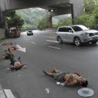 Un grupo de trabajadores duermen una pequeña siesta mientras los coches continúan circulando en la región de Chongqing (China).