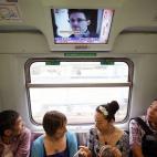 Dos pasajeros siguen una noticia sobre el exespía de la NSA Edward Snowden en un tren de Hong Kong, el 14 de junio.
