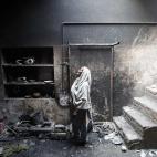 Azra, de 68 años, contempla un pájaro muerto dentro de su jaula en su casa, levantada en Badami Bagh, Pakistán, e incendiada por la multitud el 11 de marzo de 2013. Cientos de cristianos paquistaníes salieron a las calles en todo el país ex...