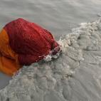 Una peregrina se baña en las aguas del río Ganges en su confluencia con el Golfo de Bengala el 14 de enero.