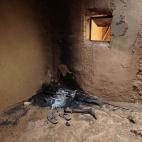 Cuerpo carbonizado que los habitantes locales creen que pertenece a un rebelde islamista quemado por los habitantes de Konna, ciudad liberada en Malí el 27 de enero de 2013.
