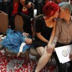 Unos recién casados se besan mientras su hijo duerme durante una boda masiva en Ciudad Juárez, el 14 de febrero de 2013. Unas 3.400 parejas se casaron en la ceremonia de la boda masiva organizada por el Registro Civil y el Gobierno para conmem...