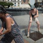 Dos mujeres intentan refrescarse en mitad de una plaza de C&oacute;rdoba