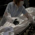 Marina G&oacute;mez, empleada de una funeraria, maneja el cad&aacute;vez de una v&iacute;ctima del coronavirus en la morgue de su empresa, M&eacute;mora, en Barcelona, el 16 de noviembre de 2020.&nbsp;