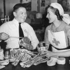 El sargento Butler, uno de tantos soldados heridos en la II Guerra Mundial, ayuda a una de las enfermeras de la Cruz Roja a preparar las huchas para la colecta del célebre Día de la Banderita, en una foto de junio de 1943.