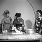Con la ayuda de una muñeca, una trabajadora de la Cruz Roja instruye a unas mujeres japonesas en las técnicas punteras del cuidado infantil en un edificio de la Cruz Roja de Tokio, alrededor de 1955.