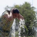 Una mujer se refresca en una de las fuentes de la ciudad debido a las altas temperaturas que se registran en Córdoba.