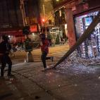 People run out of a smoke shop that they broke into as police arrive on the scene on Monday, June 1, 2020, in New York. Protests were held throughout the city over the death of George Floyd, a black man in police custody in Minneapolis who died ...