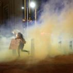 A protester runs through tear gas on the Las Vegas Strip on Sunday, May 31, 2020, in Las Vegas, during demonstrations over the death of George Floyd, who died May 25 after he was pinned at the neck by a Minneapolis police officer. (AP Photo/Stev...