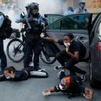 Motorists are ordered to the ground from their vehicle by police during a protest on South Washington Street, Sunday, May 31, 2020, in Minneapolis. Protests continued following the death of George Floyd, who died after being restrained by Minnea...