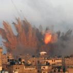 Una bola de fuego envuelve unos edificios palestinos en Rafah, al sur de Gaza tras ser alcanzados por un bombardeo israelí.