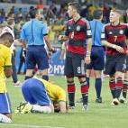 Luiz Gustavo, de Brasil, se arrodilla en el césped frente a los alborozados jugadores alemanes tras el vapuleo 7-1 que dejó fuera del mundial a la selección anfitriona.
